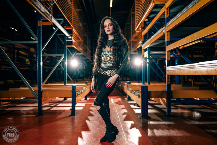 Melany Wild en tenue rock dans un entrepôt industriel, lumière de scène et look Def Leppard, photo par Julien Zannoni